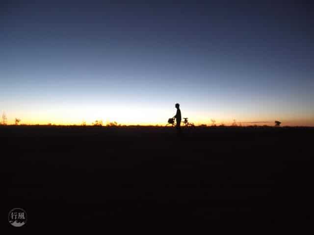 A person standing in front of a sunset